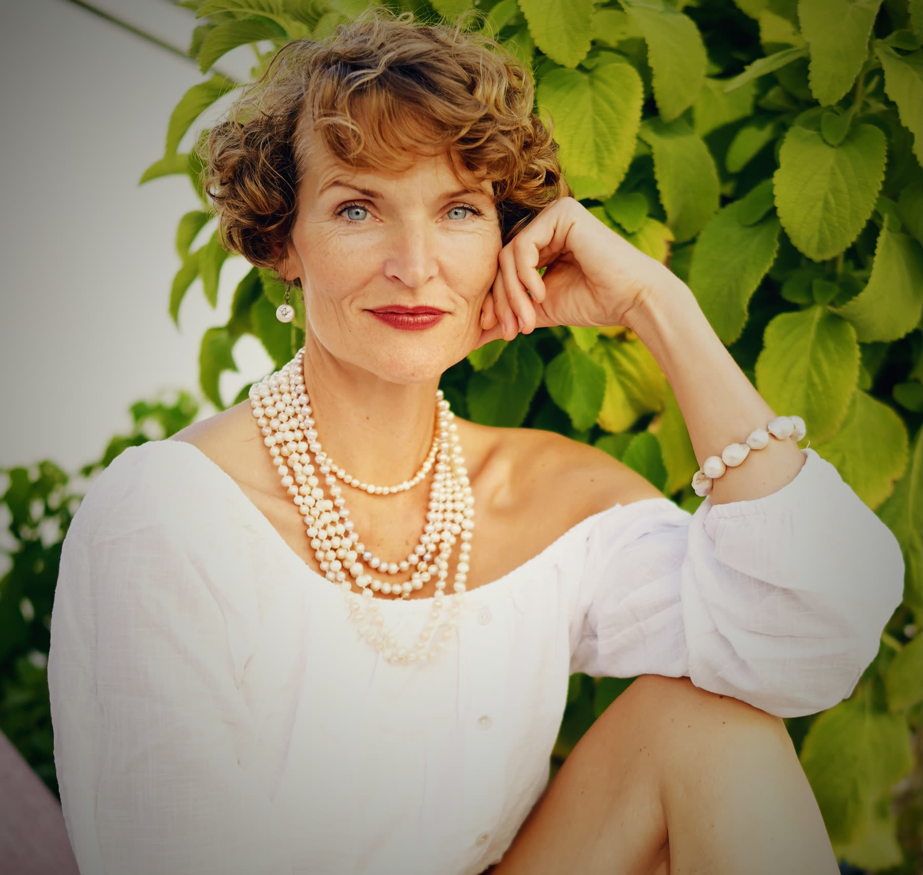 Stefanie Bruns in Weiß mit Perlenkette im Grünen